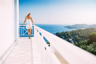 Yaz tatilinde beyaz bir villada poz veren çekici bir kadın.