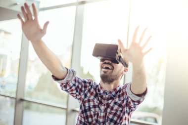 Viar gözlüklü genç adam, adam sanal gerçeklik gözlükleriyle oynuyor.