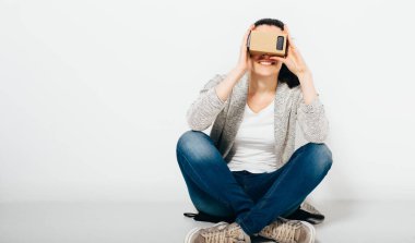 Sanal gerçeklik simülatörü kullanan bir kadın. Sanal gerçeklik gözlüğü takan genç bir kadının stüdyo fotoğrafı.