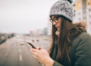 Milenyum kızının cep telefonuyla sohbet edişinin yan görüntüsü