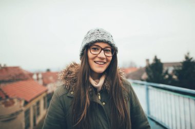 Gülümseyen kız portresi. Sonbahar şehir yürüyüşünde güzel bir milenyum kızı