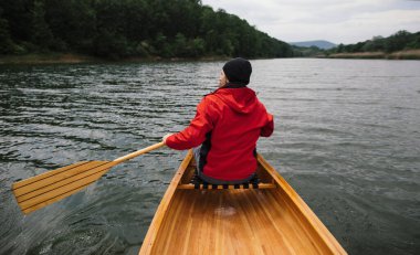 Yağmurlu gün kanosu. İnsanın kano çırpışının arka görüntüsü
