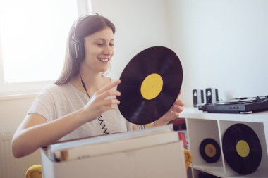 Genç bir kadın müzikten ve elinde plak tutmaktan hoşlanıyor. 