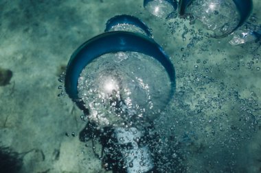 Kayalık zemini olan bir adam suyun altına dalıyor.