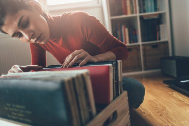 Vinil plak dinliyorum. Hippi kız evinde en sevdiği plağı arıyor.