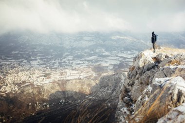 Kayalıklarda erkek turist kışın arka planda