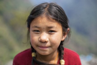 KASKI DISTRICT, NEPAL - 31 Mart 2016: Himalayalı kız doğrudan Annapurna Massif Köyü 'ne bakıyor.