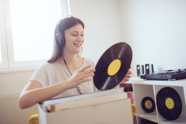 Genç bir kadın müzikten ve elinde plak tutmaktan hoşlanıyor. 