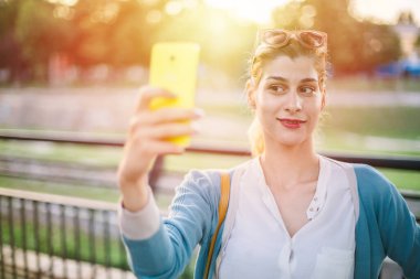 Güzel genç bir kadın selfie çekiyor. Kız dışarıda selfie çekiyor.