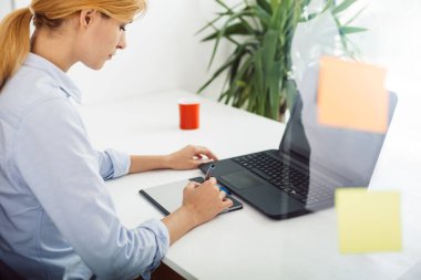 Ofisteki bilgisayarın başında çalışan iş kadını.