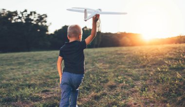 Planör uçak modeliyle oynayan çocuğun arka görüntüsü