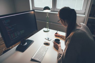 Genç iş kadını ev ofisinden saatlerce çalışıyor. Evden bilgisayarla çalışan kadın