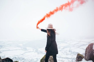 Kırmızı sis bombası olan hippi kız duman sinyali gönderiyor. Acil işaret fişeği.
