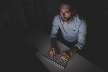 İşadamı uzun saatler bilgisayar başında çalışıyor.