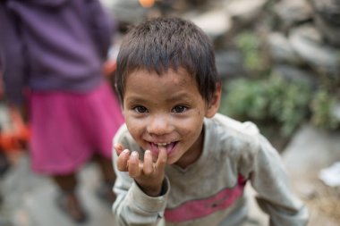 KASKI DISTRICT, NEPAL - 25 Mart 2016: Tanımlanamayan Himalayalı çocuk gülümsedi ve Kaski, Nepal Bölgesi 'nde yüzünü buruşturdu.