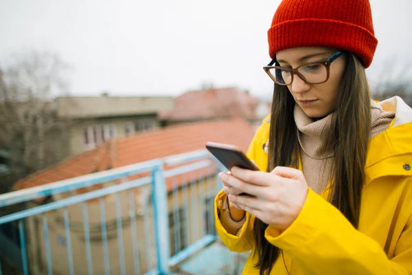 Millennial Gadis Dalam Jas Hujan Chatting Online Ponsel Pesan Sms — Stok Foto