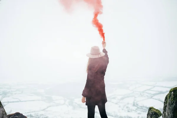 Kırmızı sis bombası olan hippi kız duman sinyali gönderiyor. Acil işaret fişeği.