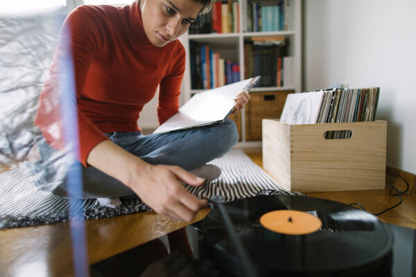 Young audiophile playing vinyl record on turntable