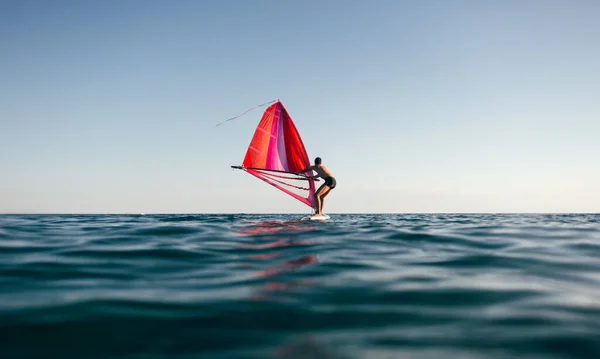 Młody Człowiek Podnosi Żagiel Windsurfingu Zachodzie Słońca Sylwetka Windsurfera Balacning — Zdjęcie stockowe