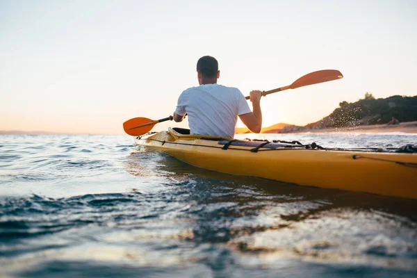 男子皮划艇在阳光灿烂的海面上航行 — 图库照片