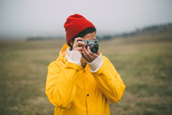 Perempuan Fotografer Dengan Jas Hujan Kuning Mengambil Foto Dengan Kamera — Stok Foto