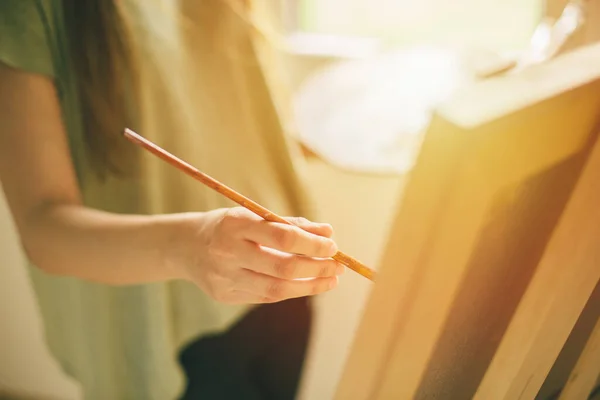 Sanatçı tuval üzerinde fırça darbeleri yapıyor