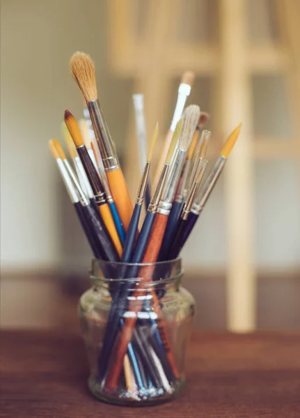 Paintbrushes in a jar at artist\'s studio