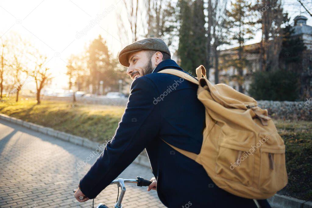 Hipster man with bicycle having fun. Bearded guy enjoy cycling in the park