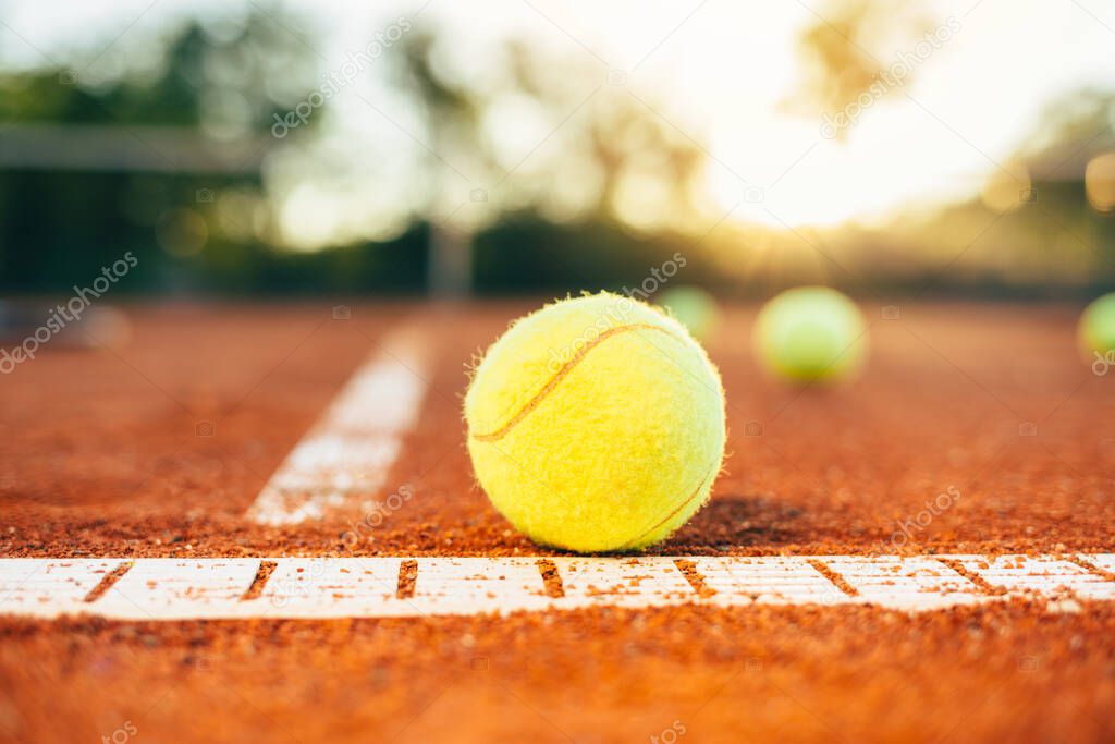 Tennis ball on tennis court. Tennis ball on baseline of tennis court