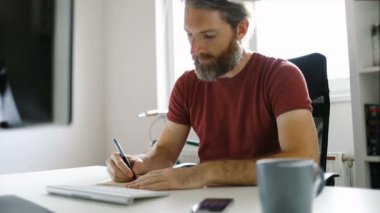 Ofis masasında çalışan serbest çalışan bir adam.