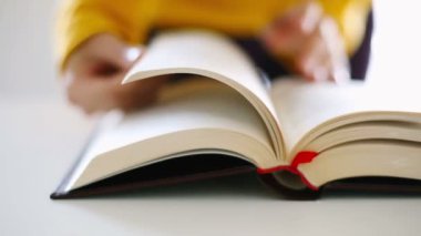 Kadın eli kapatılıyor, kitap okuyor.