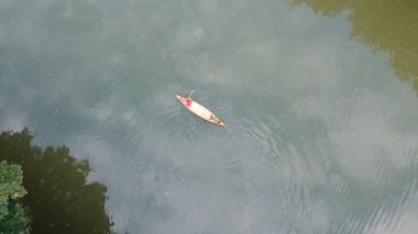 Kanocuların havadan görünüşü bir göl ormanında kürek çekmekten zevk alır. Kanonun, açık havanın, su sporlarının tadını çıkar.