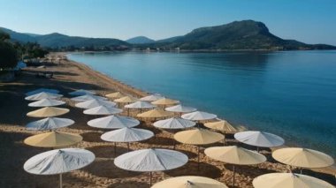 Sahil cenneti, kamış şemsiyesi ve güneşlik manzarası. Yukarıdan kumsal şemsiyeleri ve güneş yatakları