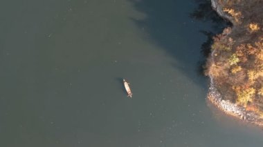 İki adam kanoda kürek çekiyor, çekim yapıyorlar.