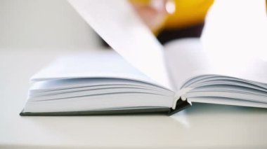 Kadın eli kapatılıyor, kitap okuyor.