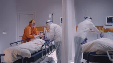 Koruyucu Takım Elbiseli Doktor Coronavirüs Hastasına Oksijen Maskesi Giydiriyor - Ağır Çekimde Geniş Dolly Vuruşu