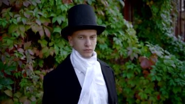 Yakışıklı genç bir adam, frak giyiyor ve maskesini takıyor.