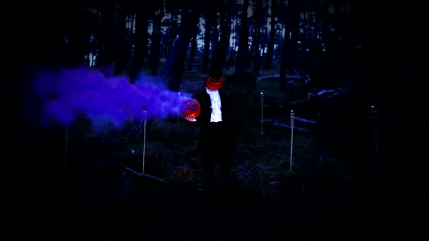 Upiorny dynia głowica człowiek trzymając a ogromny dynia z niebieski dym w las — Wideo stockowe