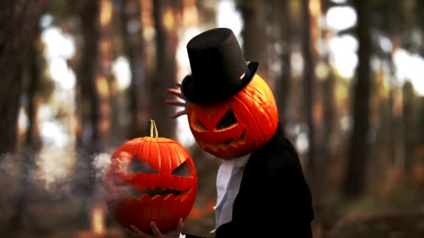 Espeluznante calabaza cabeza hombre realizar un halloween truco con humo en el bosque — Vídeo de stock