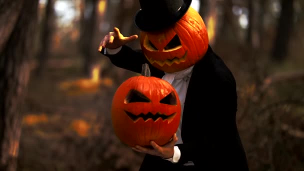 Gruseliger Mann mit Kürbisköpfen führt einen Halloween-Trick mit Rauch im Wald vor — Stockvideo