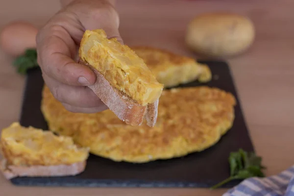 Hand Fängt Ein Stück Kartoffelomelett Auf Einem Stück Brot — Stockfoto