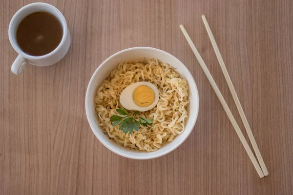 ゆで卵の麺を箸でボウルに入れ — ストック写真