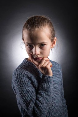 9-12 yaşında bir genç kız görünüyor içine belgili tanımlık çerçevelemek, duygusal stüdyo portre üzerinde gri bir arka plan aydınlatmalı