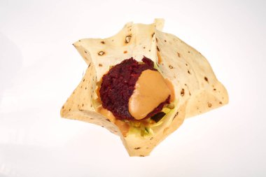 Mısır ekmeği ile pancar, havuç, soğan, lahana ve yeşil salata, nohut ve avokado bir plaka üzerinde vejetaryen burger