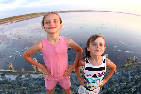 Summer portrait of a girl close-up, on a salt lake in the sunset, girl with contented and playful faces, posing for a photo