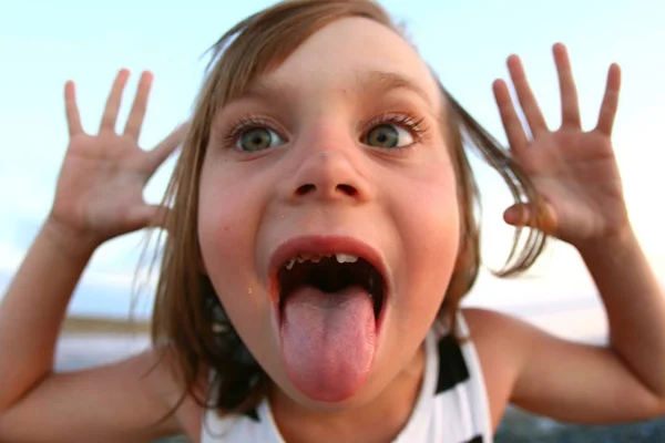Retrato de verano de una niña de cerca, en un lago salado al atardecer, niña con caras alegres y juguetonas, posando para una foto Imagen de archivo