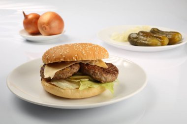 çizburger sığır patty ve, bir içkiyle dilimlenmiş salatalık turşusu ile bir plaka üzerinde
