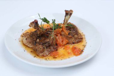 kızarmış tavuk budu domates ve baharat bir plaka üzerinde