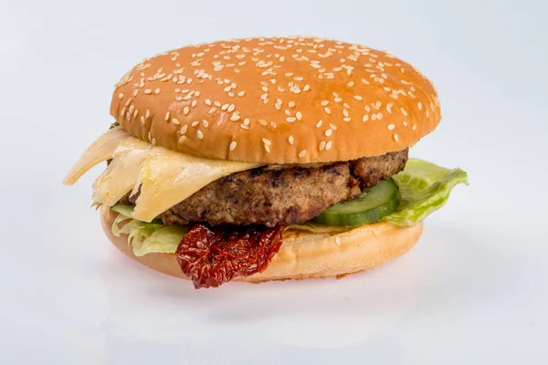 Sajtburger-val SZELET marhahús, bacon, paradicsom és sajt szeletek, fűszeres mártással, zöld saláta egy éttermi menü elszigetelt fehér alapon — Stock Fotó