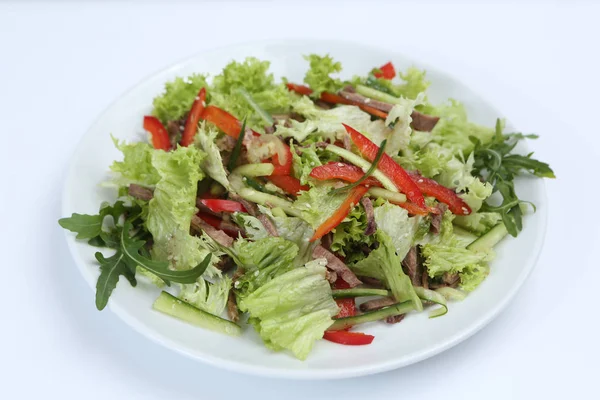 restaurant dish, green salad with cucumbers, red pepper,�bacon and arugula, healthy food, close-up, for the menu